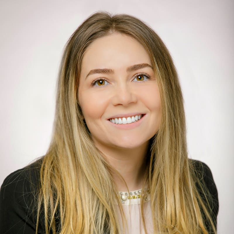 Portrait of Natalie Socher wearing a white blouse and a black blazer.