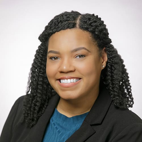 Person with a wide smile in a blue blouse